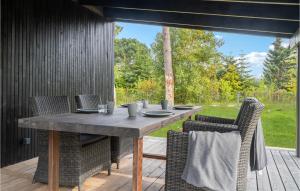 a wooden table and chairs on a wooden deck at Awesome Home In Væggerløse With Kitchen in Marielyst