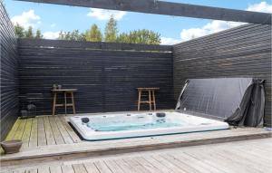 a jacuzzi tub sitting on a deck at Awesome Home In Væggerløse With Kitchen in Marielyst +17 photos