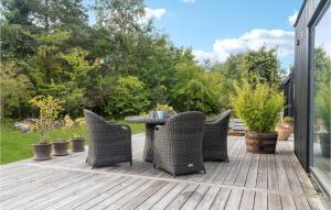 a patio with wicker chairs and a table on a deck at Awesome Home In Væggerløse With Kitchen in Marielyst