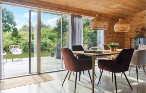 a dining room with a table and chairs and a patio at Awesome Home In Væggerløse With Kitchen in Marielyst