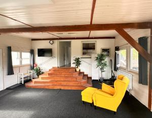 a living room with yellow chairs and stairs at Hannis-Hof in Meinerzhagen
