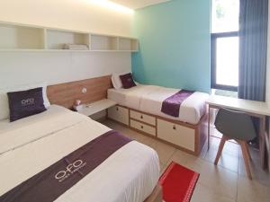 PareにあるOFO Kost Premium Kampung Inggris Pare Syariah Mitra RedDoorzのベッドが2つと窓があるホテルの部屋 +76枚の写真