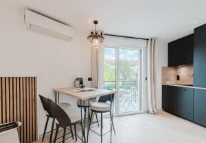 a kitchen and dining room with a table and chairs at Appart Hotel Neostelia in Annecy