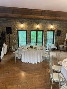 a large white table with chairs in a room at Pensiunea Alex in Marga