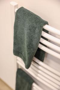 une serviette verte sur le dossier d'une chaise blanche dans l'établissement N2 Les Arcades de Montaudry - Terrasse - Parking, à Albi