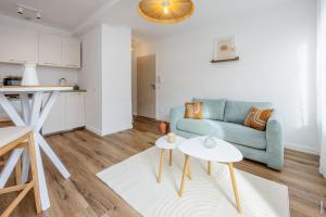 un salon avec un canapé bleu et une table dans l'établissement N2 Les Arcades de Montaudry - Terrasse - Parking, à Albi 35 autres photos