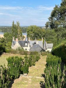 an old house on a farm with a field of trees at Porterie du château Clim Wifi Terrasse Bord Loire in Gennes