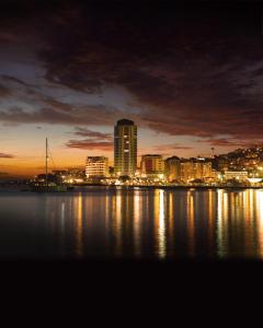 a city skyline at night with the water at Simon Hotel in Fort-de-France