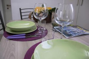 una mesa de madera con dos copas de vino y un plato en La Mansarda, en Melzo