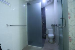 a bathroom with a toilet and a glass shower stall at De Karanganjar Inn in Berni
