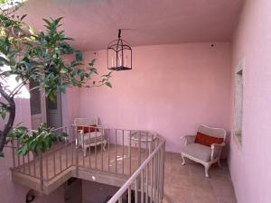 a balcony with two chairs and a chandelier at Maison Marmont in Vela Luka