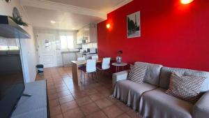ein Wohnzimmer mit einem Sofa und einer roten Wand in der Unterkunft Hotel Costa Blanca Rojales in Rojales