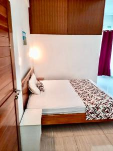 a small bedroom with a bed in a room at Coastal lodge in Port Mathurin