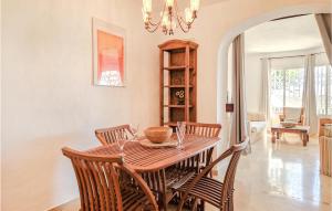 a dining room with a table with chairs and a chandelier at Lovely Apartment In Mijas With Wifi in Mijas