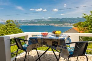 ein Tisch und Stühle auf einem Balkon mit Blick auf das Wasser in der Unterkunft Apartment Andjelko G in Šilo