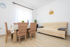 ein Esszimmer mit Tisch und Stühlen und einem Bett in der Unterkunft Apartment Andjelko G in Šilo