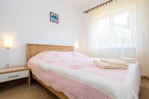 ein Schlafzimmer mit einem Bett mit zwei Handtüchern darauf in der Unterkunft Apartment Andjelko G in Šilo