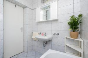 ein weißes Badezimmer mit Waschbecken und Spiegel in der Unterkunft Apartment Andjelko G in Šilo + 28 Fotos
