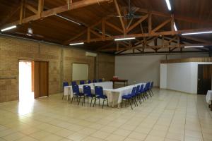 a large room with a table and blue chairs at Pousada Villa dei Colori in Araraquara
