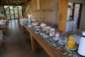 una larga mesa de madera con un montón de comida. en Pousada Villa dei Colori, en Araraquara 22 fotos más