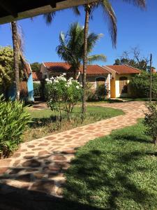 un camino de ladrillo frente a una casa con palmeras en Pousada Villa dei Colori, en Araraquara