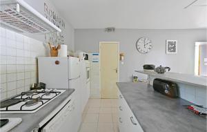 a kitchen with a stove and a white refrigerator at 3 Bedroom Nice Home In Mazan in Mazan