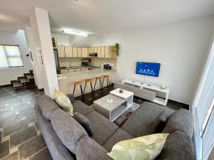 a living room with a couch and a kitchen at Salty Sunset Self Catering in Langstrand