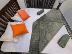 a bed with four pillows and an umbrella on it at Costels Mirissa in Mirissa