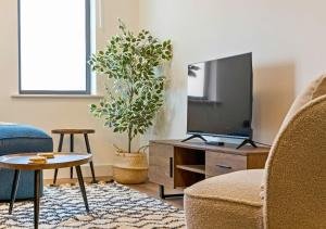 Una sala de estar con televisión y un sofá. en Central 1BD with Free Underground Parking!, en Cheltenham