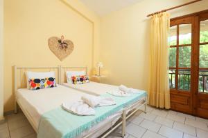 a bedroom with two beds and a heart on the wall at Asteras hotel in Hanioti