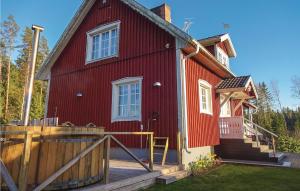 a red house with a wooden fence in front of it at Beautiful Home In Vilshult With Kitchen in Vilshult