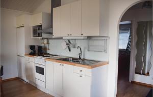 a kitchen with white cabinets and a sink at Two-Bedroom Holiday Home In Lottorp in Löttorp