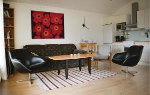 a living room with a couch and a table and chairs at Two-Bedroom Holiday Home In Lottorp in Löttorp