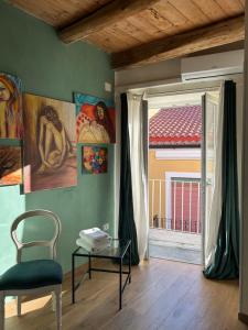 a room with a chair and a table and a window at B&B Casa CamiLory in San Lucido