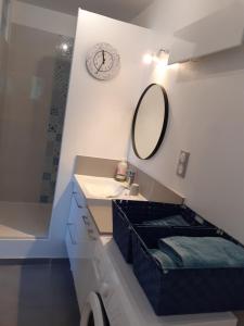 łazienka z umywalką i zegarem na ścianie w obiekcie maison mitoyenne avec piscine Un moment chez Diane w mieście Grasse