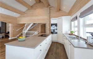 a kitchen with white cabinets and a wooden ceiling at Lovely Home In Sjusjøen With Sauna in Sjusjøen