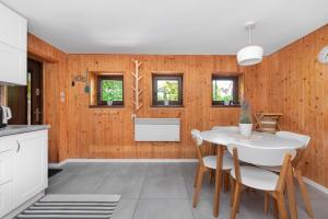a kitchen and dining room with a white table and chairs at Domek letniskowy Patricia in Sulęczyno