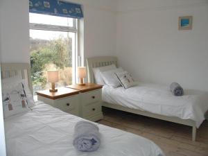 two beds in a room with a window at Ley Park in Bideford +16 photos