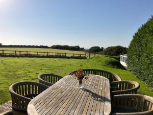a wooden table with chairs and a vase of flowers on it at Ley Park in Bideford