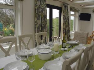 a dining room table with white plates and wine glasses at Ley Park in Bideford