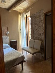 a bedroom with a bed and a chair and a window at B&B Casa CamiLory in San Lucido