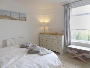 a bedroom with a bed and a dresser and a window at Ley Park in Bideford