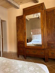 a bedroom with a large wooden cabinet with a mirror at B&B Casa CamiLory in San Lucido