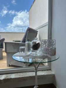 a glass table on a balcony with a chair and a table at B&B Casa CamiLory in San Lucido