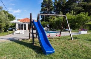 a playground with a blue slide in a park at Apartments Zeljka B in Mundanije
