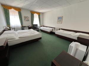 um quarto com quatro camas num quarto com carpete verde em Hotel Omega Brno em Brno mais 37 fotografias