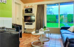 un soggiorno con un divano, una TV e un tavolo di 3 Bedroom Awesome Home In Oostduinkerke a Oostduinkerke