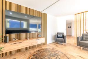 a living room with a large flat screen tv at Alpin Chic - Aare Jungfrau AG in Grindelwald