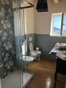 a bathroom with a toilet and a glass shower at B&B Casa CamiLory in San Lucido