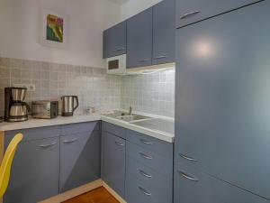 eine Küche mit blauen Schränken und einer Spüle in der Unterkunft Feriendorf Rugana - Budget 1-Raum Appartement mit Terrasse A10 in Dranske + 2 Fotos